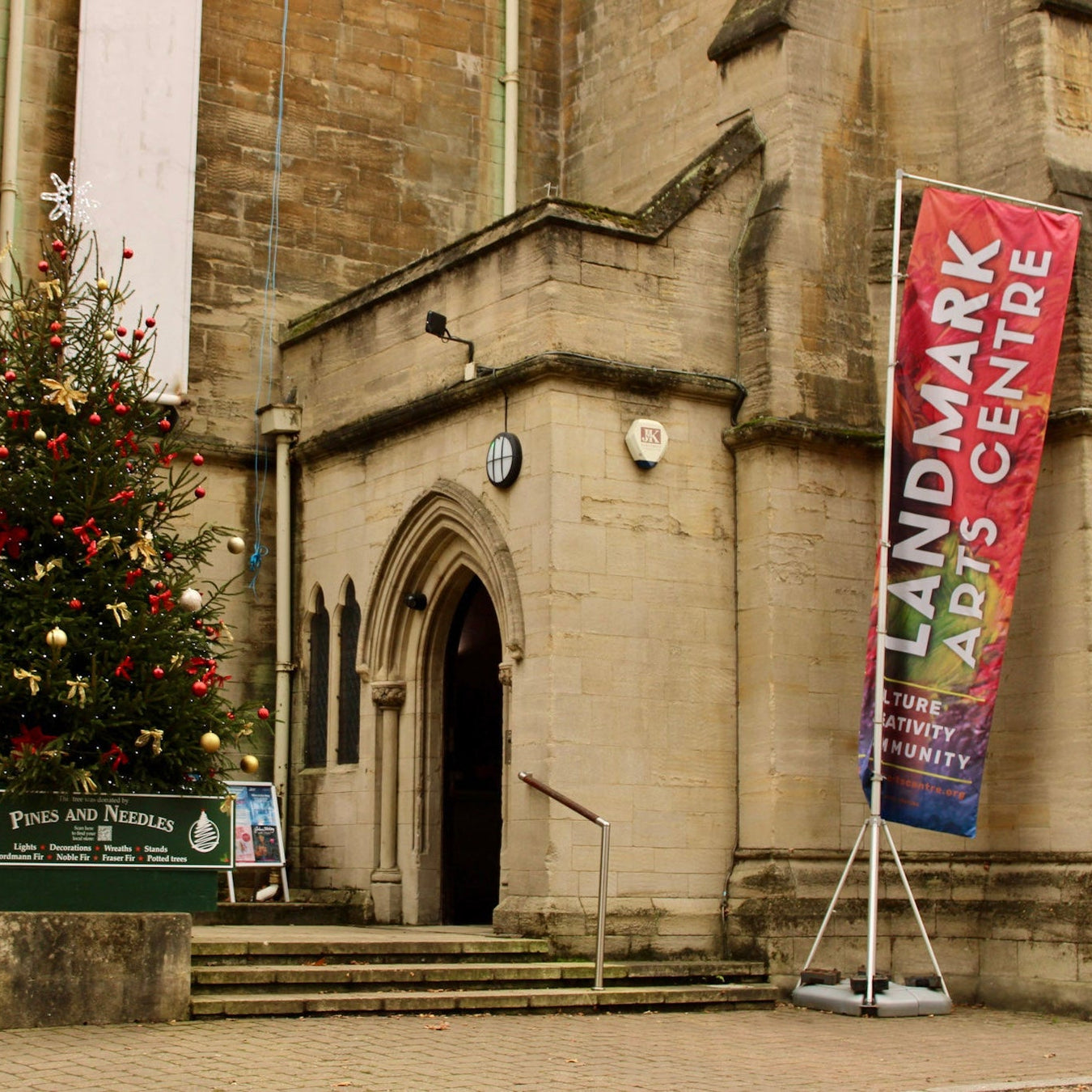 Christmas tree in front of a building with a 'Landmark Arts Centre' banner.